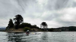 Hernán Doro, cofundador de Terrazul Expediciones Villa Pehuenia, navega el lago Aluminé, rodeado por montañas y bosques patagónicos.